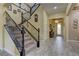 Open foyer featuring tile flooring, a staircase with iron railing and a decorative glass front door at 12121 Cabo Rojo Ave, Las Vegas, NV 89138