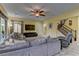 Comfortable living room with large sectional sofa, tile flooring and staircase access at 12121 Cabo Rojo Ave, Las Vegas, NV 89138