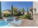 Beautiful pool area with water features, lush landscaping, and travertine stone at 12121 Cabo Rojo Ave, Las Vegas, NV 89138
