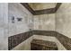 Modern walk-in shower with decorative tile accents, built-in bench, and sleek fixtures, offering a luxurious experience at 12121 Cabo Rojo Ave, Las Vegas, NV 89138