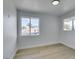 Well-lit bedroom with light hardwood floors and dual windows overlooking the neighborhood at 1225 Arrowhead Ave, Las Vegas, NV 89106