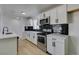 Bright kitchen featuring white cabinets, stainless steel appliances, and a stylish black tile backsplash at 1225 Arrowhead Ave, Las Vegas, NV 89106