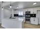 Modern kitchen with white cabinets, stainless steel appliances, an island and a black backsplash at 1225 Arrowhead Ave, Las Vegas, NV 89106