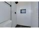 Modern bathroom shower with white subway tile, black trim, and black honeycomb tile floor at 1225 Arrowhead Ave, Las Vegas, NV 89106