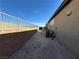 Narrow backyard featuring desert landscaping, HVAC equipment, and fenced perimeter at 2040 Port Royal Dr, Laughlin, NV 89029