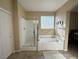 A bright and airy bathroom featuring a shower, tub and window at 2040 Port Royal Dr, Laughlin, NV 89029