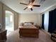 A carpeted bedroom with ceiling fan and large windows, with an ensuite bath at 2040 Port Royal Dr, Laughlin, NV 89029