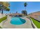 Backyard pool surrounded by lush green landscaping, a covered patio, and a red tiled roof home at 2240 Grayson Cir, Henderson, NV 89014