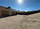 View of a spacious backyard with a retaining wall and sliding glass doors at 2266 Carved Canyon Ln, Laughlin, NV 89029