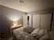 Neutral bedroom with queen sized bed and side table with pictures and lamp at 2266 Carved Canyon Ln, Laughlin, NV 89029