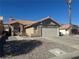 Exterior featuring a tile roof, low maintenance landscaping, and attached garage at 2266 Carved Canyon Ln, Laughlin, NV 89029