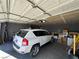 Garage with white SUV, storage boxes, tools, and an open garage door at 2266 Carved Canyon Ln, Laughlin, NV 89029