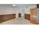 Cozy living room featuring wood paneling and neutral-toned tile flooring at 2367 E Hacienda Ave, Las Vegas, NV 89119