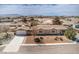 Aerial view of a home with a two-car garage, long driveway, simple landscaping, and mountain views in the distance at 3100 S Fallwood St, Pahrump, NV 89048