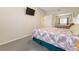 Bedroom includes carpet, a ceiling fan, a wall-mounted TV, and mirrored closet doors at 313 Haley Way # D, Mesquite, NV 89027