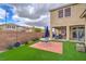 Backyard featuring artificial grass, patio, and well-maintained landscaping at 3237 Mist Effect Ave, Henderson, NV 89044