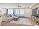 Spacious living room with plush sectional, carpeted floors, and large windows at 3237 Mist Effect Ave, Henderson, NV 89044