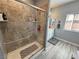 Bathroom featuring a shower with tan and brown tile, glass doors and a large window for natural light at 3341 S Big Sky Way, Pahrump, NV 89048