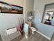 Cozy half bathroom featuring a framed mountain picture, white toilet, and modern fixtures at 3341 S Big Sky Way, Pahrump, NV 89048