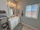 Well-lit bathroom with a white vanity, framed mirror, and window with a view of the landscape at 3341 S Big Sky Way, Pahrump, NV 89048