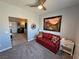 Bedroom featuring a red futon, modern decor, and an adjoining room with a barn door at 3341 S Big Sky Way, Pahrump, NV 89048