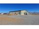 Metal home with a covered patio and fenced in area is surrounded by beautiful mountain views at 3341 S Big Sky Way, Pahrump, NV 89048