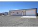 Exterior view of a commercial garage with a large garage door and surrounding gravel at 3341 S Big Sky Way, Pahrump, NV 89048