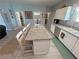 Open concept kitchen features an island with granite countertops, white cabinetry and adjacent pantry and laundry room at 3341 S Big Sky Way, Pahrump, NV 89048
