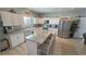 Well-lit kitchen with white cabinetry, granite countertops, stainless steel appliances, and large island with seating at 3341 S Big Sky Way, Pahrump, NV 89048