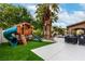 Backyard with artificial turf, a playhouse, and palm trees at 4401 Lilac Glen Dr, Las Vegas, NV 89129