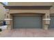 Exterior view of a two-car garage with brick paved driveway and well-maintained landscaping at 4625 Ridgeley Ave # 103, North Las Vegas, NV 89084