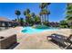 Community pool with lounge chairs, surrounded by palm trees at 4730 E Craig Rd # 1093, Las Vegas, NV 89115