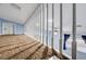 View of the loft featuring neutral carpet, a white railing, and a view of the room below at 4775 N Grand Canyon Dr, Las Vegas, NV 89129