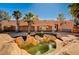 Back of house featuring a rock-lined pool with palm trees and covered terraces at 4775 N Grand Canyon Dr, Las Vegas, NV 89129