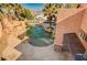 View of the rock-lined backyard pool from under a covered patio at 4775 N Grand Canyon Dr, Las Vegas, NV 89129
