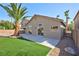 Backyard boasts a lush lawn, palm tree, and covered patio area at 4900 Cascade Pools Ave, Las Vegas, NV 89131