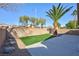 Backyard featuring a small artificial lawn, patio, rock landscaping, and block wall at 4900 Cascade Pools Ave, Las Vegas, NV 89131