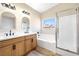 Bathroom featuring double sinks, quartz countertops, a soaking tub, and a glass-enclosed shower at 4900 Cascade Pools Ave, Las Vegas, NV 89131