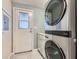 A modern laundry room features gray cabinets, a door to the outside and an up to date washer and dryer at 518 Topaz Ave, Henderson, NV 89015