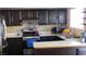 The U-shaped kitchen with stainless steel appliances, dark wood cabinetry, and tiled backsplash offers a functional layout at 5856 Sutcliffe Cir, Las Vegas, NV 89110