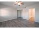 Spacious bedroom featuring gray wood flooring, a ceiling fan, and access to an on-suite bathroom at 6160 Rumrill St # 201, Las Vegas, NV 89113