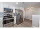 Modern kitchen featuring stainless steel appliances, white cabinets, gray backsplash, and wood flooring at 6160 Rumrill St # 201, Las Vegas, NV 89113