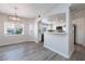 Open concept kitchen and breakfast nook with white cabinets, stainless appliances, and gray wood flooring at 6160 Rumrill St # 201, Las Vegas, NV 89113
