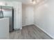 Kitchen eating nook with white cabinets, stainless steel refrigerator, gray wood flooring, and white door at 6160 Rumrill St # 201, Las Vegas, NV 89113