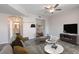 Living room with neutral color scheme, ceiling fan, modern furniture, and an archway to the bathroom at 6160 Rumrill St # 201, Las Vegas, NV 89113