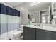 Bathroom featuring a sink with vanity, a toilet, and a shower with a blue and white curtain at 703 Sleeping City Ave, Henderson, NV 89015