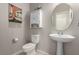 Cozy powder room features a pedestal sink, round mirror, and decorative wall hangings at 703 Sleeping City Ave, Henderson, NV 89015