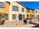 Charming townhome with colorful exterior, patio seating, and a decorative front door wreath at 703 Sleeping City Ave, Henderson, NV 89015