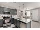 Modern kitchen featuring stainless steel appliances, gray cabinets, and a breakfast bar at 703 Sleeping City Ave, Henderson, NV 89015