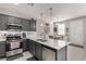 Stylish kitchen showcasing gray cabinets, stainless steel appliances and quartz countertops at 703 Sleeping City Ave, Henderson, NV 89015